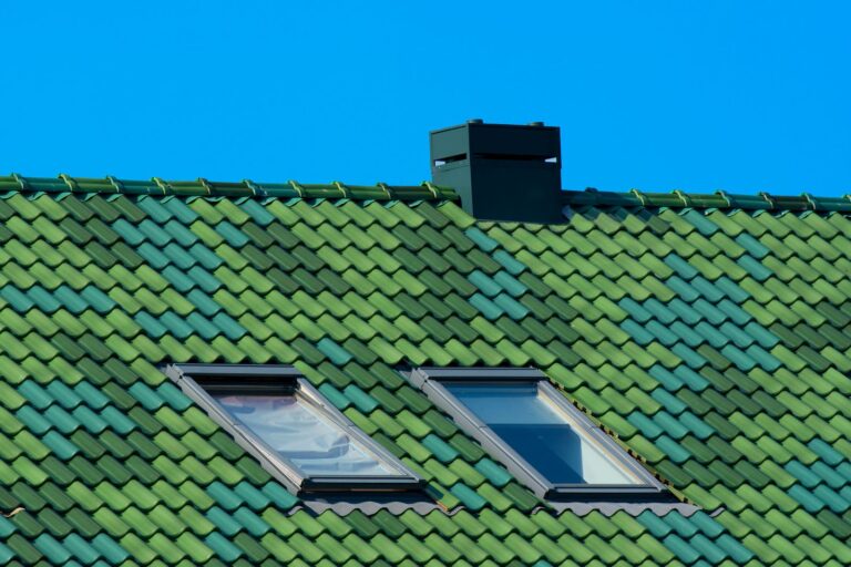 Two skylights with metal flashing installed on a pitched residential roof against a clear blue sky in Northern Utah